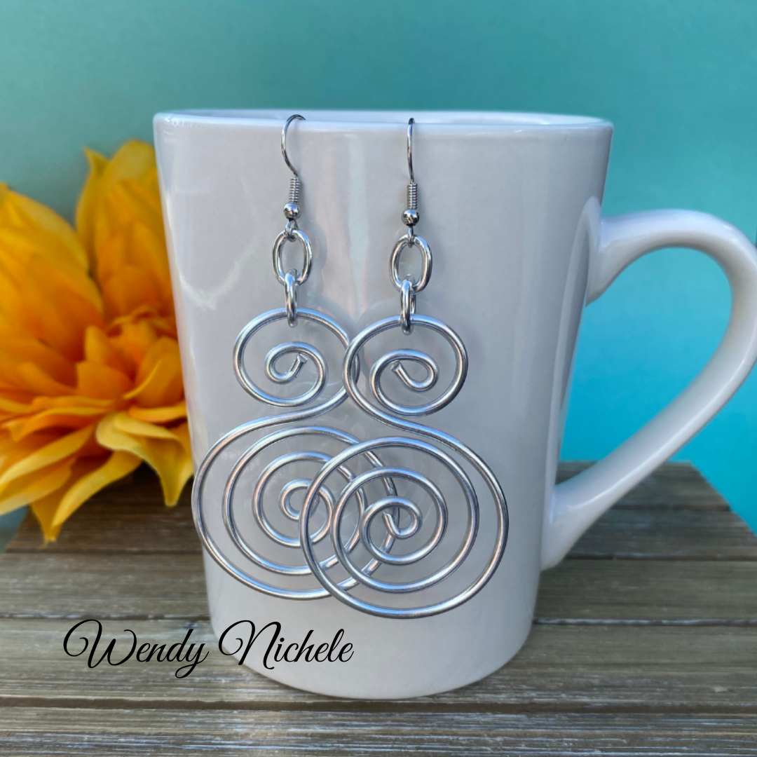 Double spiral earrings on mug.webp