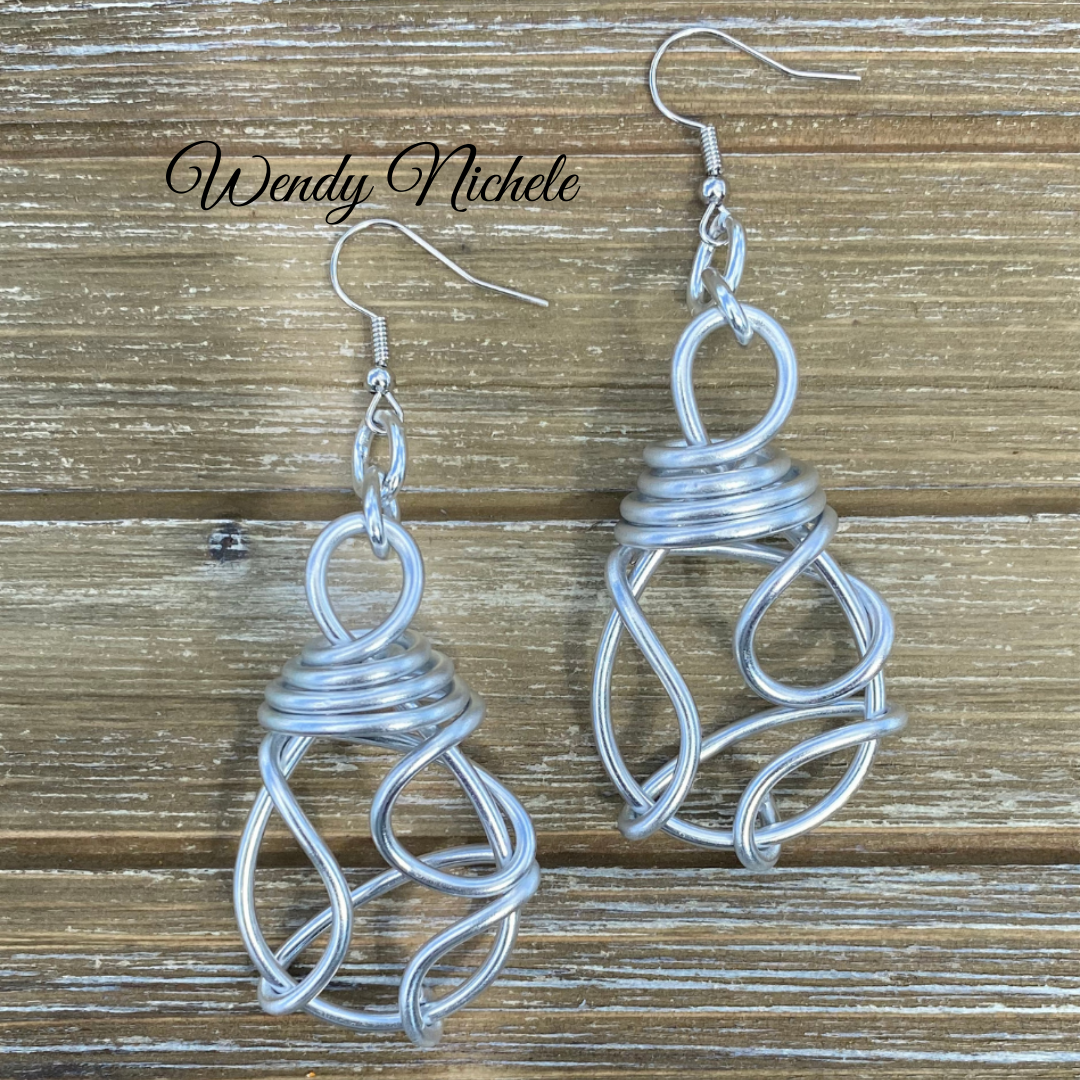 Knotted aluminum earrings on woodgrain.webp